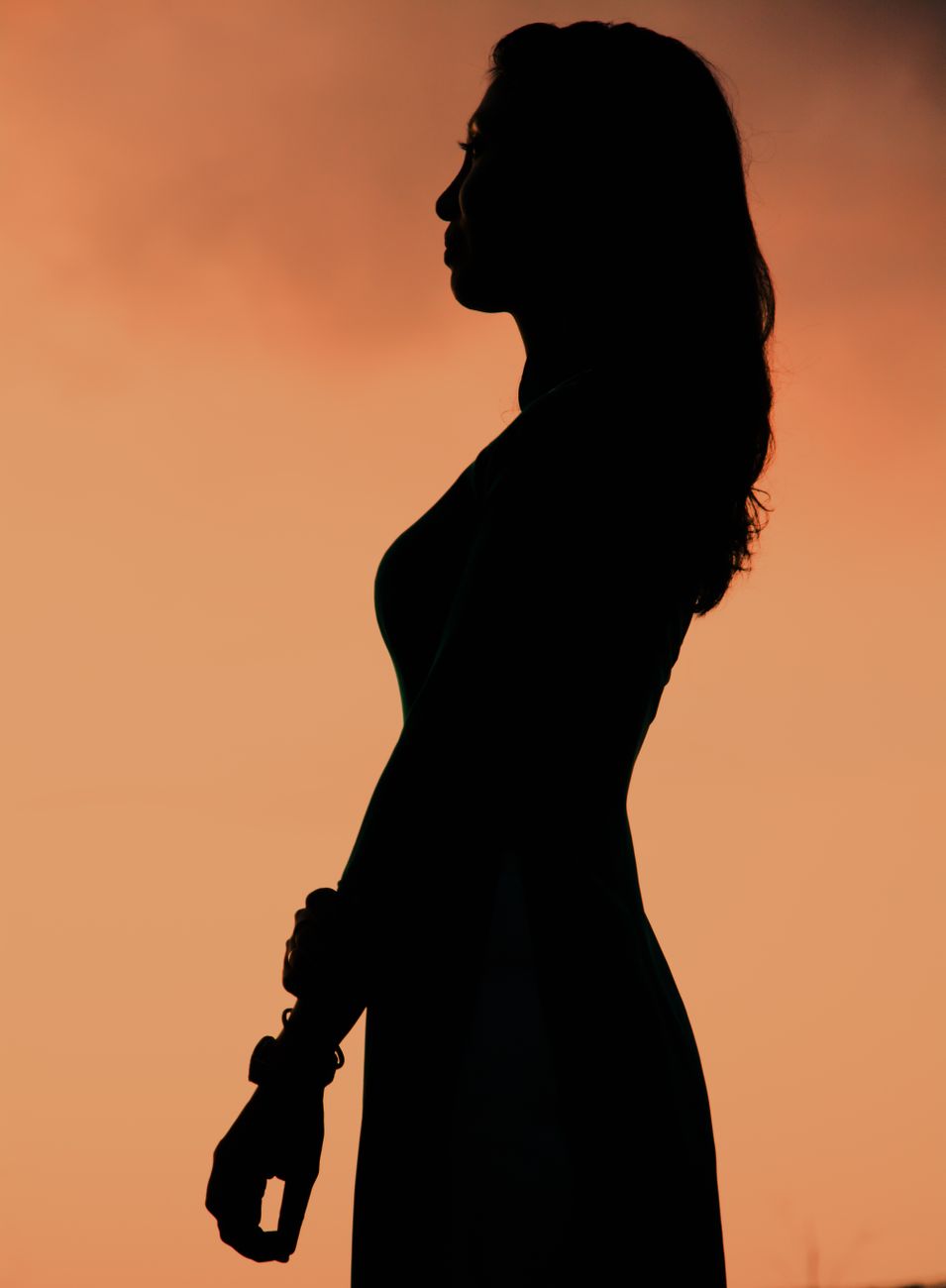 Woman silhouetted at golden hour, empowered and free